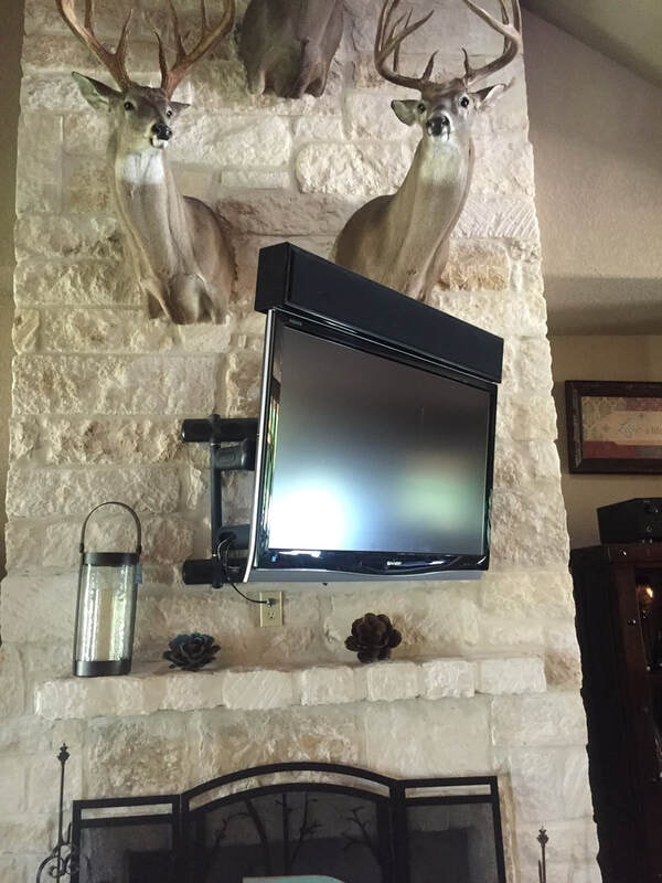 Dual TV mounts above stone fireplace with custom AV integration
